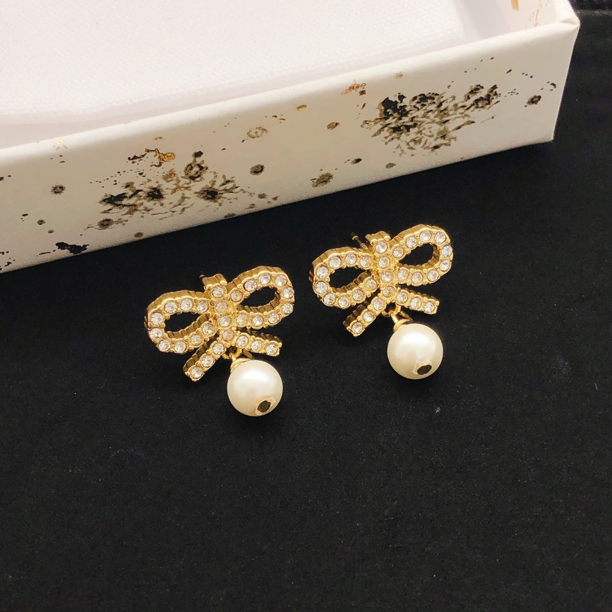 Martin Graham stud earrings in polished metal-tone – close-up detail